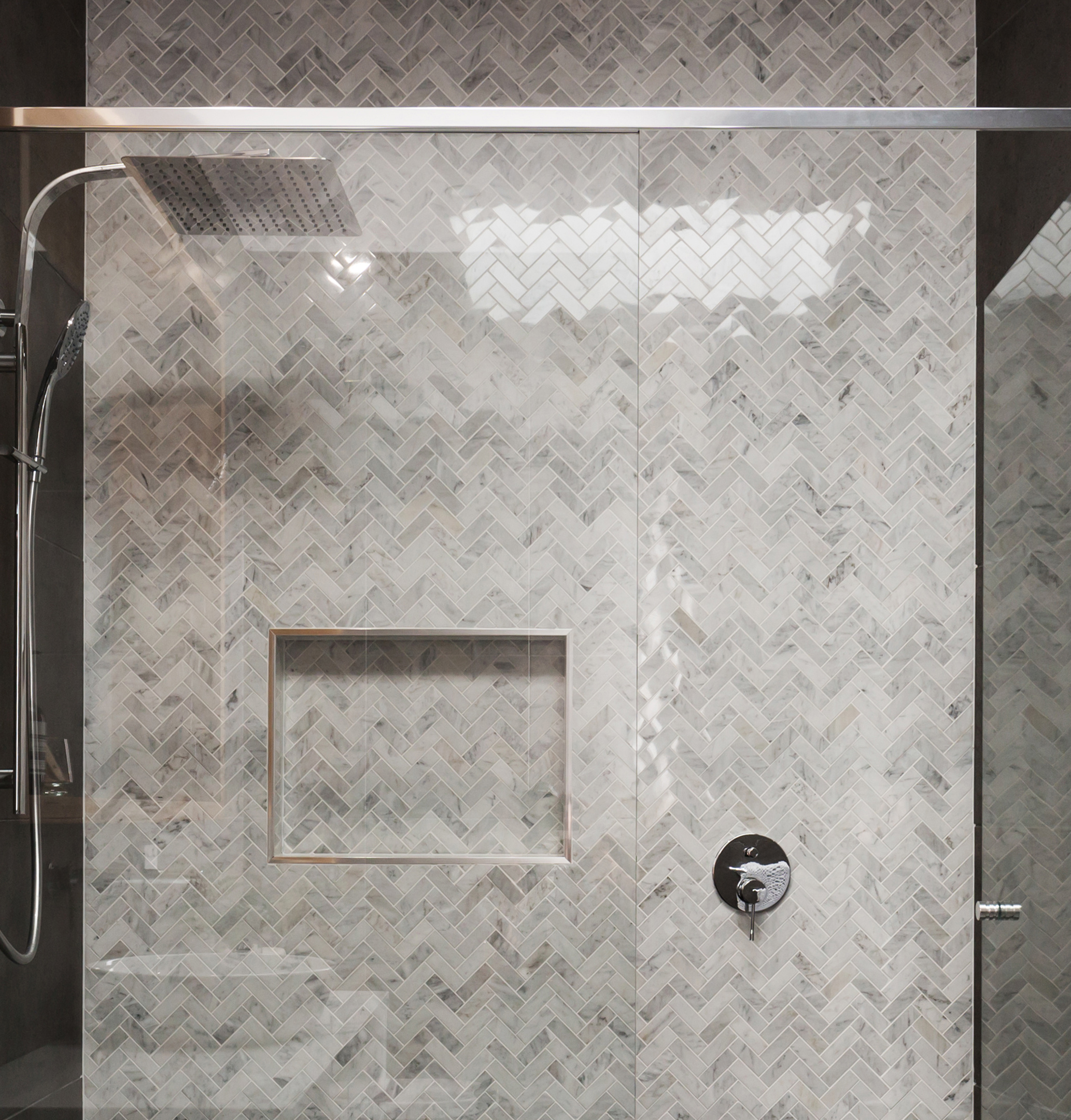 Recessed shower niches with patterned tiles offer a stylish way to store shampoo and soap.